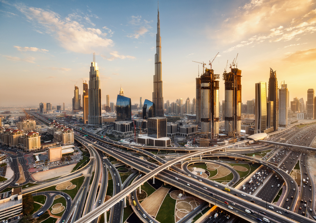 Spectacular skyline of Dubai, UAE.  Futuristic modern architecture of a big city at sunset with a large highway intersection.
